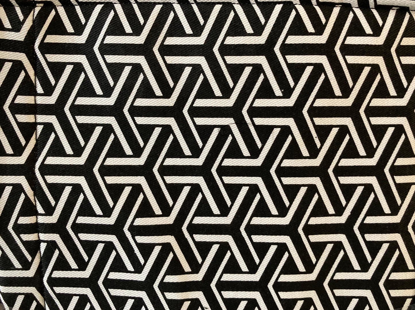 A black and white geometric patterned tote bag close up of the fabric surface.