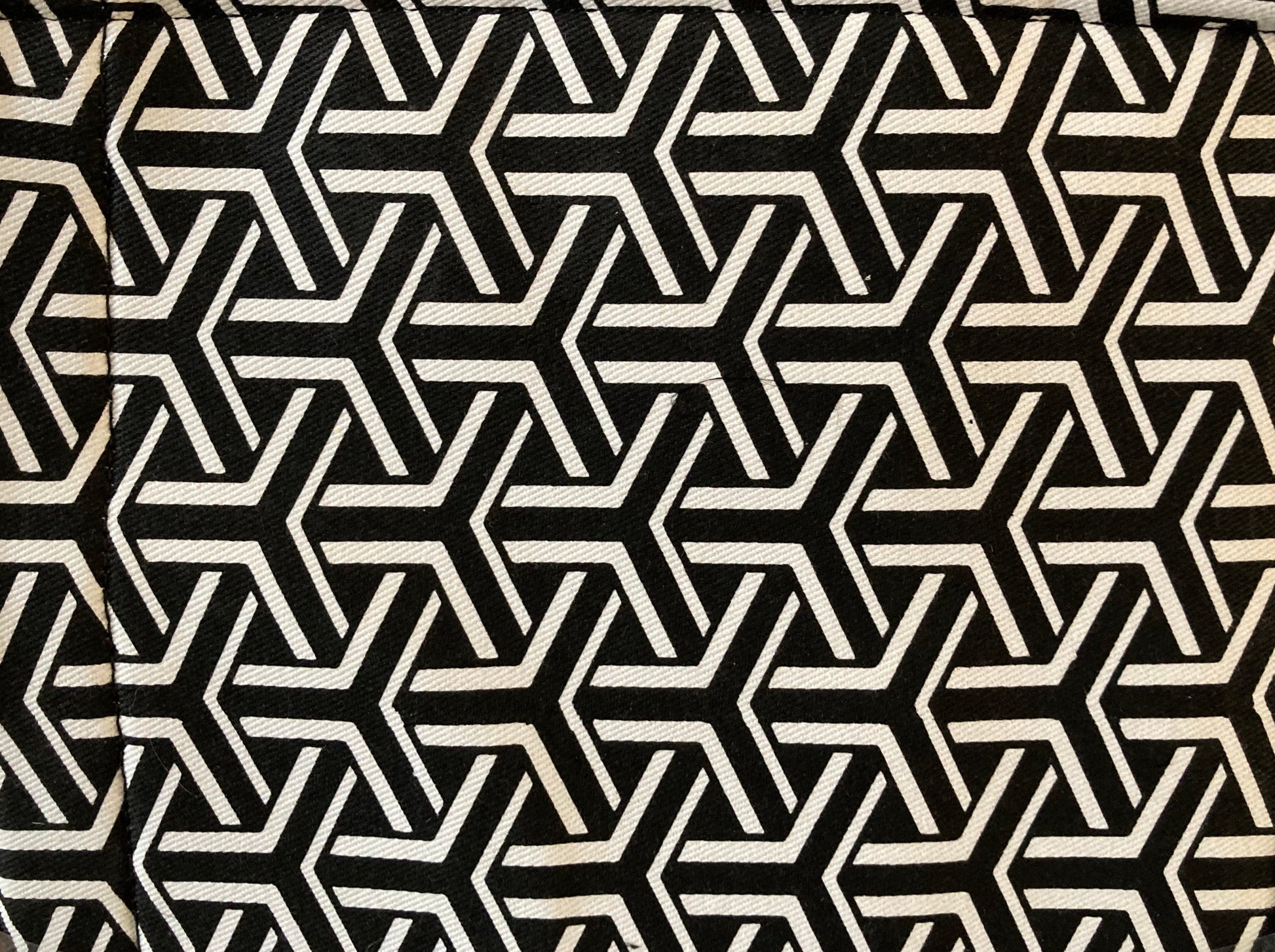 A black and white geometric patterned tote bag close up of the fabric surface.