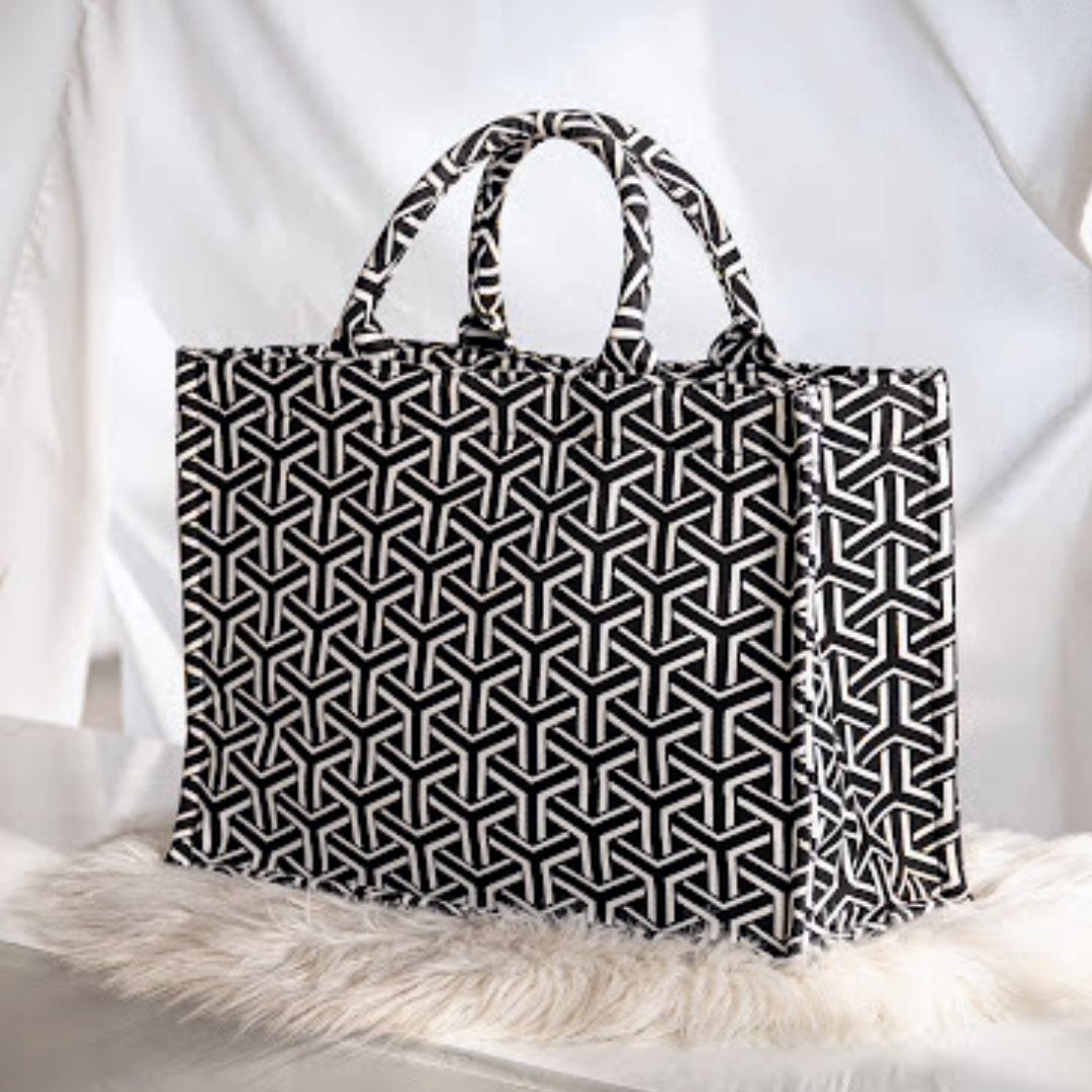 Black and white geometric patterned bag on a soft white background.