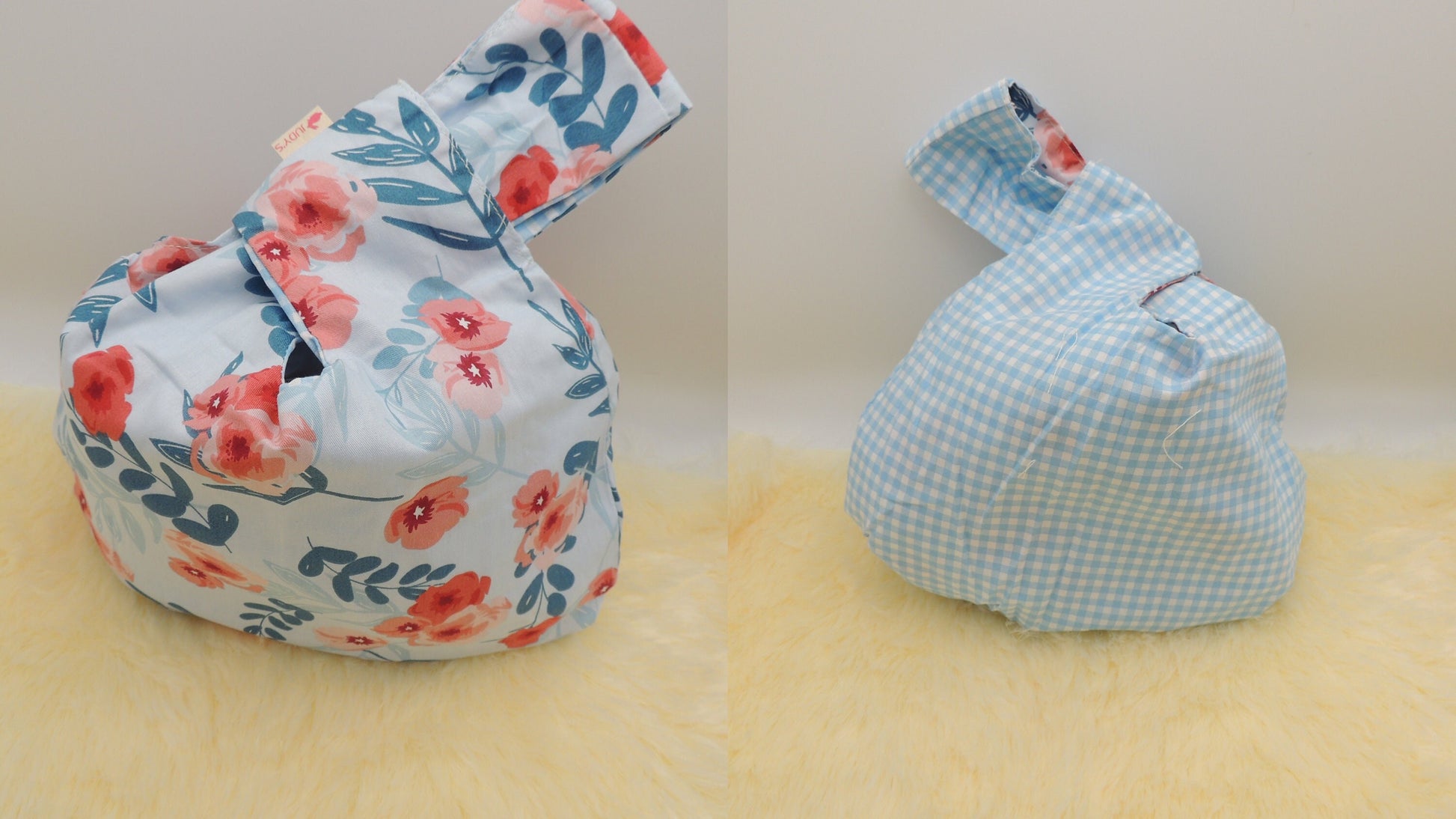 Japanese Knot Bag - Reversible and Compact Wrist Bag - Two Fabrics in One in a Pink and Blue Flowers on White background and Blue Check pattern.