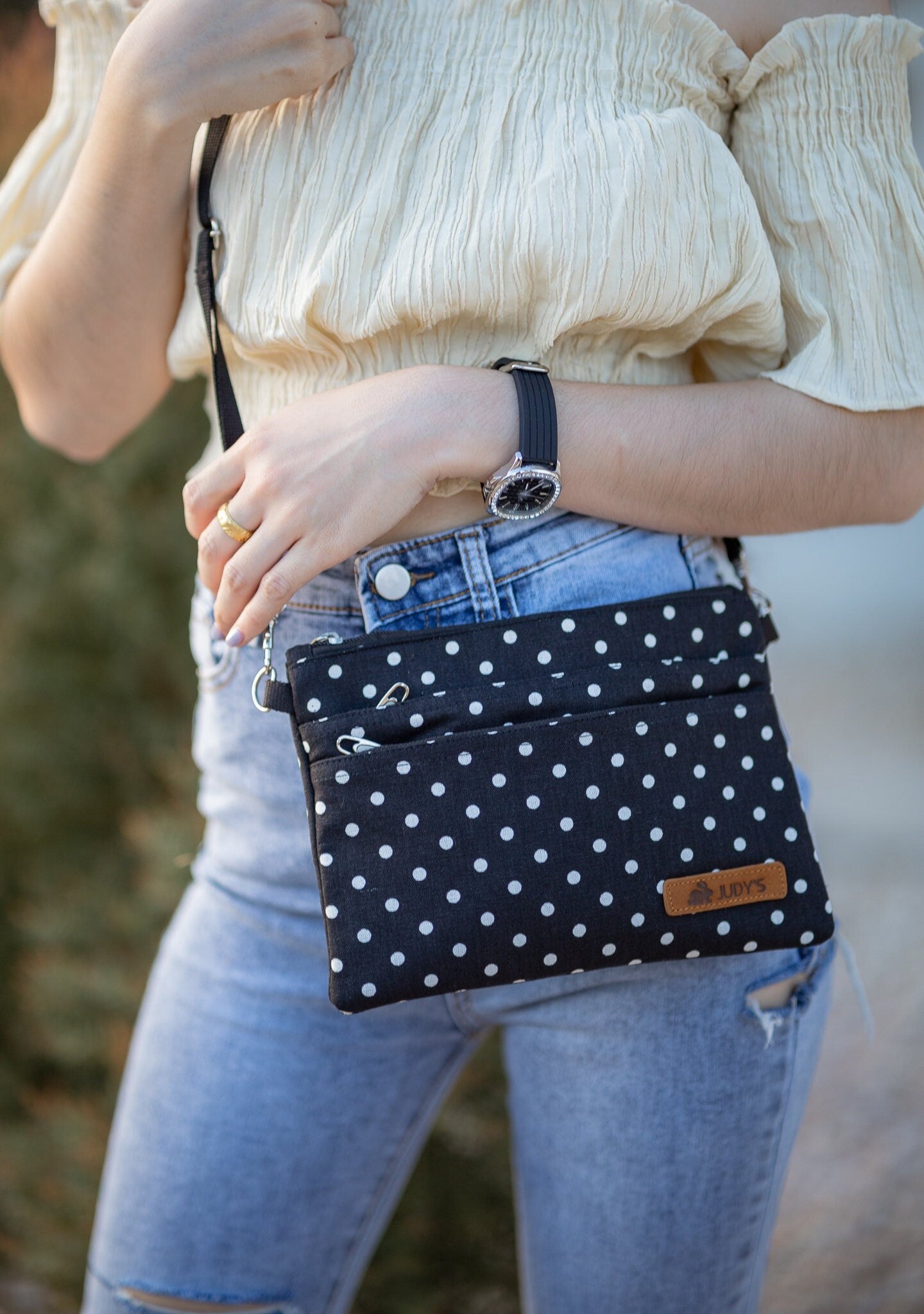 Girl with Cross Body bag in Black with Small White Circles pattern.