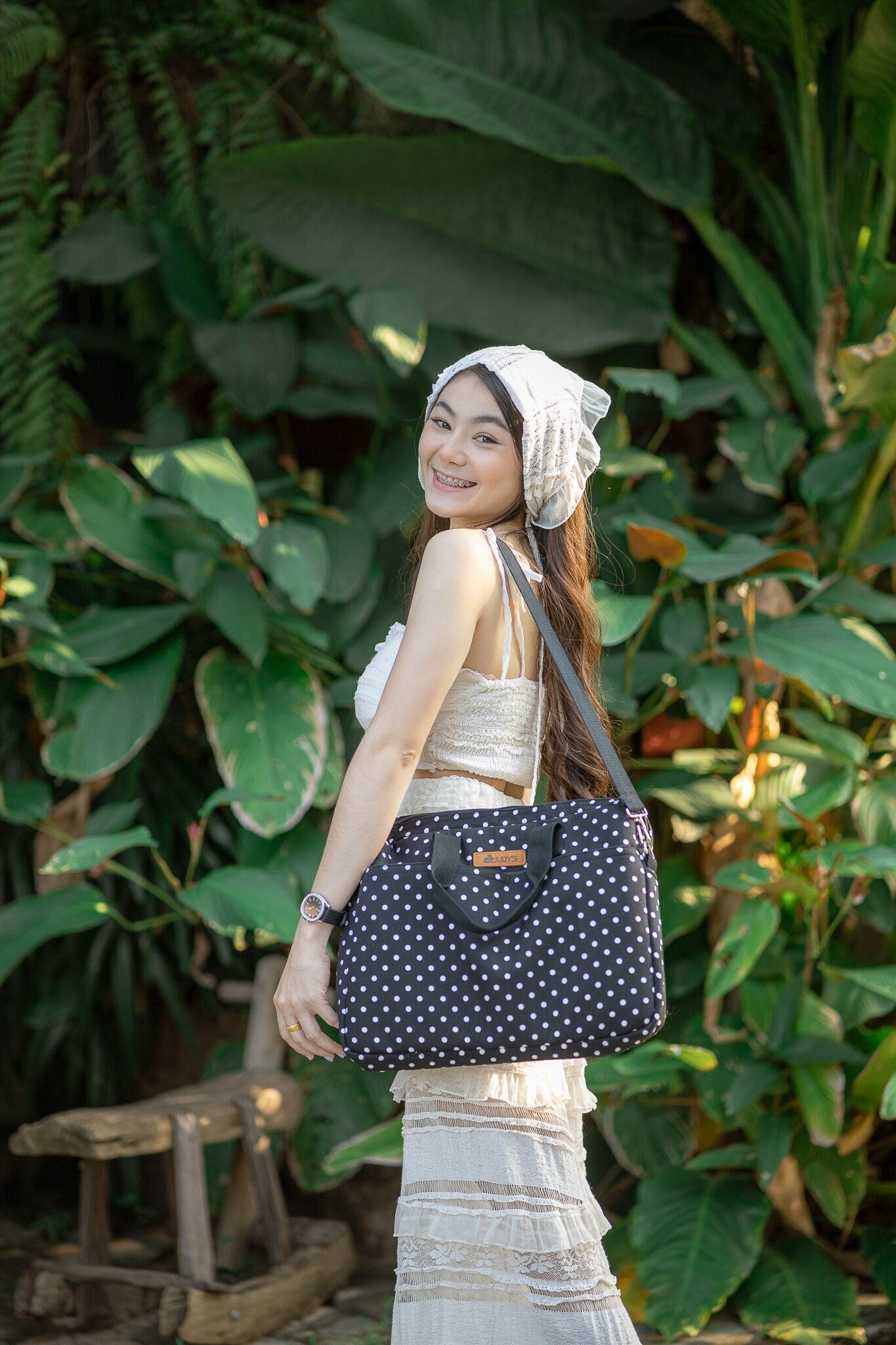 Girl with Notebook Laptop Computer bag using shoulder strap.  Black bag with small white dots pattern.